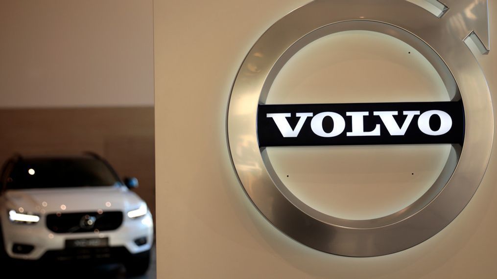FILE - In this Feb. 6, 2020 file photo a Volvo car is parked behind the Volvo logo in the lobby of the company's corporate headquarters, in Brussels.  Volvo says it will make only electric vehicles by 2030.(AP Photo/Virginia Mayo, File)